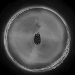 Little-planet thermal view of a person in the water alongside a vessel at night