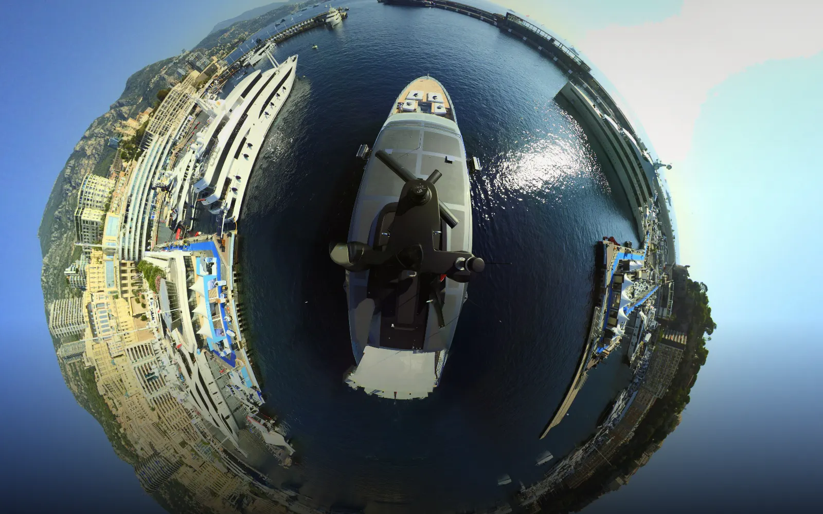 Port Hercule, Monaco, from the masthead camera, seen as a complete 360° little-planet view: the vessel's foredeck at the centre, the marina, superyachts and the hillside town curved around it.